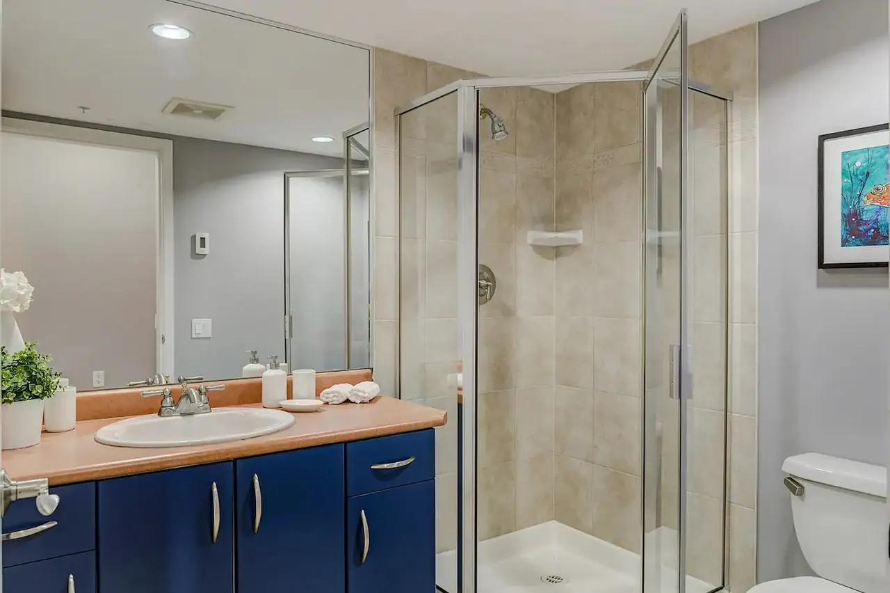 Second bathroom with a vanity and a corner glass shower