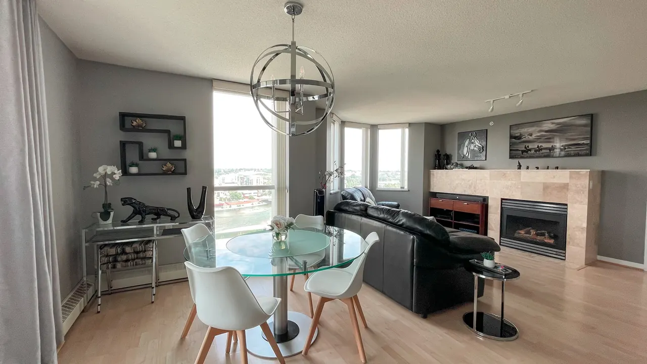 Living and dining area with the tiled gas fireplace and corner windows